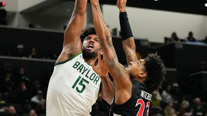 Jan 7, 2025; Waco, Texas, USA;  Baylor Bears forward Norchad Omier (15) scores a basket as Cincinnati Bearcats forward Dillon Mitchell (23) defends during the first half at Paul and Alejandra Foster Pavilion. Mandatory Credit: Chris Jones-Imagn Images