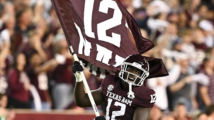 Nov 16, 2024; College Station, Texas, USA; Texas A&M Aggies defensive lineman Nana Boadi-Owusu (12) runs out with a flag riot to the game against the New Mexico State Aggies at Kyle Field. Mandatory Credit: Maria Lysaker-Imagn Images 