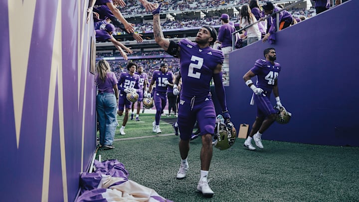 Redshirt freshman cornerback Caleb Presley slaps hands with fans.
