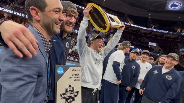 Penn State wrestler Masanosuke Ono lifts the championship trophy at the NCAA Wrestling Championships at Rocket Arena.