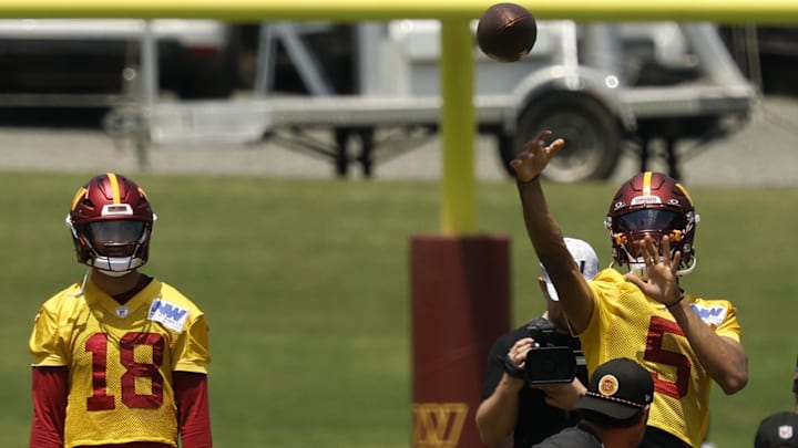 Jun 10, 2025; Ashburn, VA, USA; Washington Commanders quarterback Jayden Daniels (5) passes the ball as Commanders quarterback Marcus Mariota (18) looks on during drills on day one of minicamp at Commanders Park. Mandatory Credit: Geoff Burke-Imagn Images