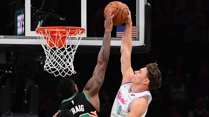 Apr 2, 2025; Boston, Massachusetts, USA; Miami Heat guard Pelle Larsson (9) dunks the ball past Boston Celtics forward Torrey Craig (12) during the second half at TD Garden. Mandatory Credit: Bob DeChiara-Imagn Images
