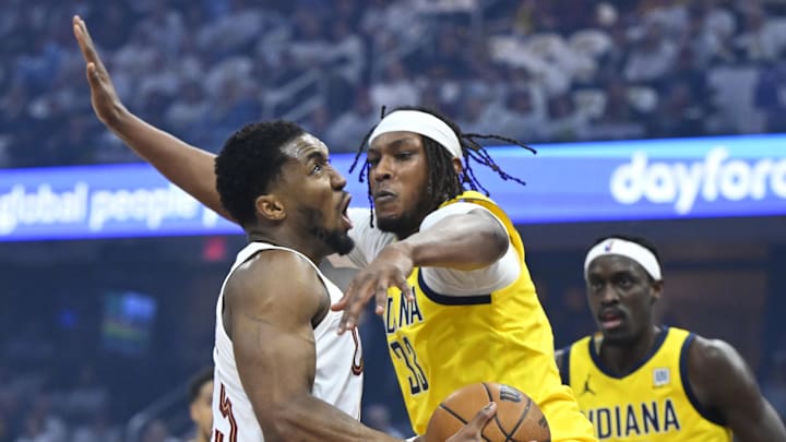 May 6, 2025; Cleveland, Ohio, USA; Cleveland Cavaliers guard Donovan Mitchell (45) drives against Indiana Pacers center Myles Turner (33) and forward Pascal Siakam (43) in the first quarter during game two of the second round of the 2025 NBA Playoffs at Rocket Arena. Mandatory Credit: David Richard-Imagn Images