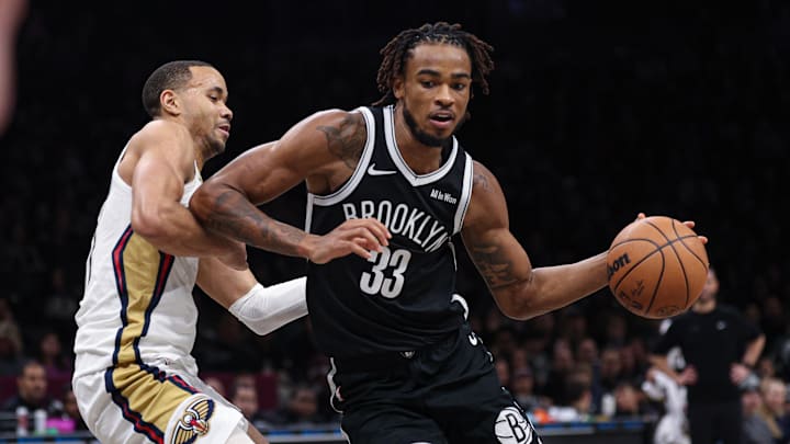 Dec 6, 2025; Brooklyn, New York, USA; Brooklyn Nets center Nic Claxton (33) dribbles as New Orleans Pelicans guard Jordan Hawkins (24) defends during the second half at Barclays Center. Mandatory Credit: Vincent Carchietta-Imagn Images