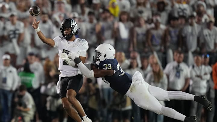 Sep 27, 2025; University Park, Pennsylvania, USA; Oregon Ducks quarterback Dante Moore (5) is tackled by Penn State Nittany Lions defensive end Dani Dennis-Sutton (33) during the first quarter at Beaver Stadium. Mandatory Credit: James Lang-Imagn Images