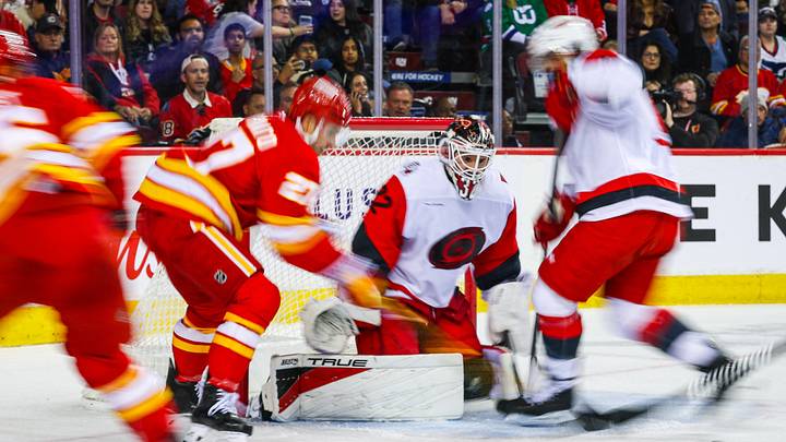Oct 18, 2026; Calgary, Alberta, CAN; Carolina Hurricanes goaltender Brandon Bussi (32) makes a save against Calgary Flames right wing Matt Coronato (27) during the second period at Scotiabank Saddledome. Mandatory Credit: Sergei Belski-Imagn Images