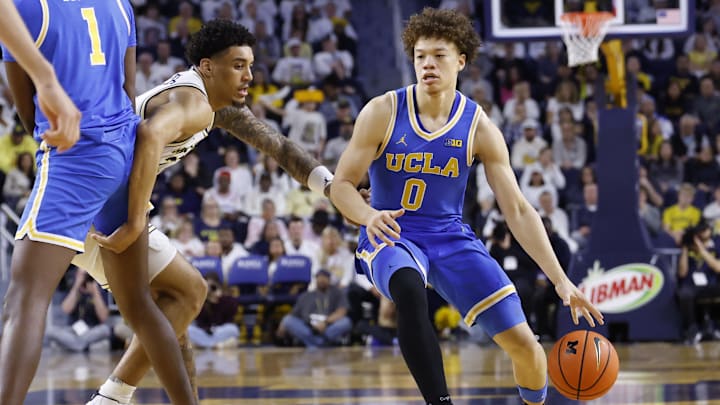 Feb 14, 2026; Ann Arbor, Michigan, USA; UCLA Bruins guard Trent Perry (0) dribbles defended by Michigan Wolverines forward Yaxel Lendeborg (23) in the second half at Crisler Center. Mandatory Credit: Rick Osentoski-Imagn Images