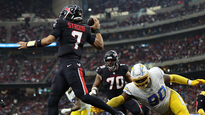 Jan 11, 2025; Houston, Texas, USA; Houston Texans quarterback C.J. Stroud (7) avoids a tackle by Los Angeles Chargers defensive tackle Teair Tart (90) during the second quarter in an AFC wild card game at NRG Stadium. Mandatory Credit: Troy Taormina-Imagn Images Jan 11, 2025; Houston, Texas, USA; Houston Texans quarterback C.J. Stroud (7) avoids a tackle by Los Angeles Chargers defensive tackle Teair Tart (90) during the second quarter in an AFC wild card game at NRG Stadium. Mandatory Credit: Troy Taormina-Imagn Images