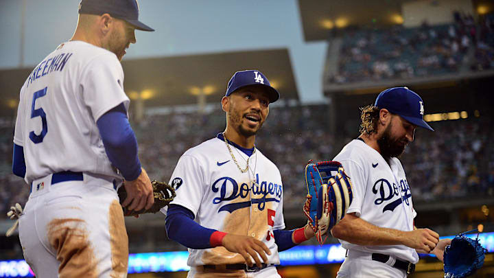 Aug 23, 2022; Los Angeles, California, USA; Los Angeles Dodgers right fielder Mookie Betts (50) is greeted by first baseman Freddie Freeman (5) and starting pitcher Tony Gonsolin (26) after catching the fly ball of Milwaukee Brewers third baseman Luis Urias (2) during the second inning at Dodger Stadium. Mandatory Credit: Gary A. Vasquez-Imagn Images Aug 23, 2022; Los Angeles, California, USA; Los Angeles Dodgers right fielder Mookie Betts (50) is greeted by first baseman Freddie Freeman (5) and starting pitcher Tony Gonsolin (26) after catching the fly ball of Milwaukee Brewers third baseman Luis Urias (2) during the second inning at Dodger Stadium. Mandatory Credit: Gary A. Vasquez-Imagn Images