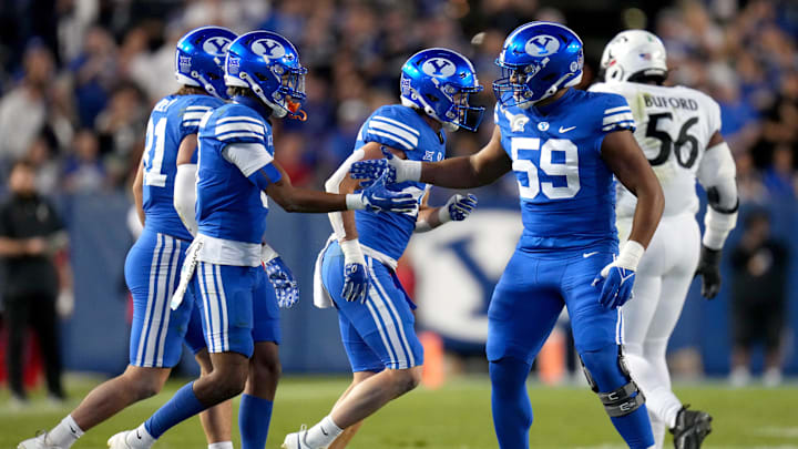 Brigham Young Cougars defensive end Logan Lutui (59) congratulates Brigham Young Cougars cornerback Jakob Robinson (0) on a defensive stop in the first quarter during a college football game between the Brigham Young Cougars and the Cincinnati Bearcats, Friday, Sept. 29, 2023, at LaVell Edwards Stadium in Provo, Utah.