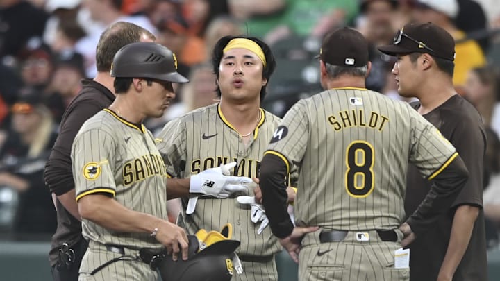 Jul 26, 2024; Baltimore, Maryland, USA;  San Diego Padres medical staff speak with San Diego Padres shortstop Ha-Seong Kim (7) after a play at first base against the Baltimore Orioles at Oriole Park at Camden Yards. Mandatory Credit: Tommy Gilligan-Imagn Images
