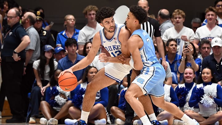 Mar 7, 2026; Durham, North Carolina, USA; Duke Blue Devils forward Cameron Boozer (12) controls the ball in front of North Carolina Tar Heels guard Seth Trimble (7) during the first half at Cameron Indoor Stadium. Mandatory Credit: Rob Kinnan-Imagn Images