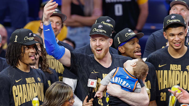 Jun 22, 2025; Oklahoma City, Oklahoma, USA; Oklahoma City Thunder center Isaiah Hartenstein (55) holds his son during the NBA Championship trophy presentation after game seven of the 2025 NBA Finals against the Indiana Pacers at Paycom Center. Mandatory Credit: Alonzo Adams-Imagn Images