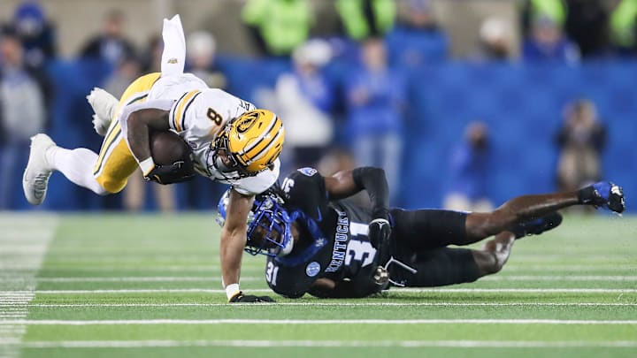 Missouri Tigers running back Nathaniel Peat runs for a gain as Kentucky Wildcats defensive back Maxwell Hairston (31) makes the tackle in the second quarter on Oct. 14, 2023.