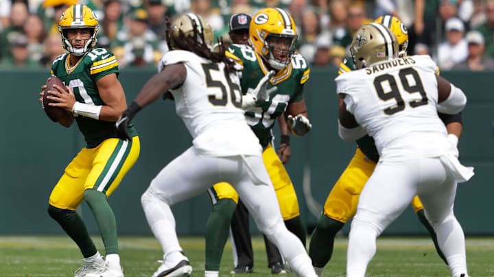 Green Bay Packers quarterback Jordan Love (10) looks to pass while pressured by New Orleans Saints linebacker Demario Davis (56)