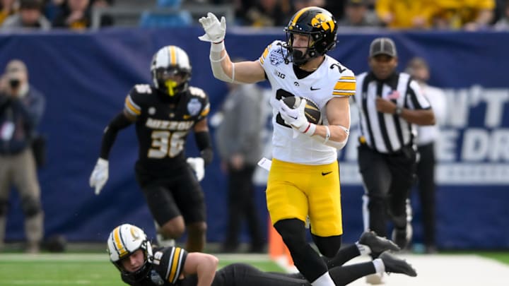 Dec 30, 2024; Nashville, TN, USA;  Iowa Hawkeyes wide receiver Kaden Wetjen (21) returns a kickoff for a touchdown against the Missouri Tigers during the first half at Nissan Stadium. Mandatory Credit: Steve Roberts-Imagn Images