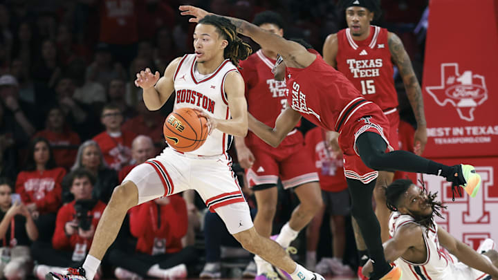 Jan 6, 2026; Houston, Texas, USA; Houston Cougars guard Kingston Flemings (4) attempts to get a rebound away from Texas Tech Red Raiders guard Jaylen Petty (11) during the first half at Fertitta Center. 
