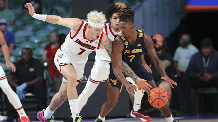Nov 28, 2024; Paradise Island, Bahamas, BHS;  Louisville Cardinals forward Kasean Pryor (7) tries to steal the ball from West Virginia Mountaineers guard Javon Small (7) during the first half at Imperial Arena at the Atlantis resort.  Mandatory Credit: Kevin Jairaj-Imagn Images