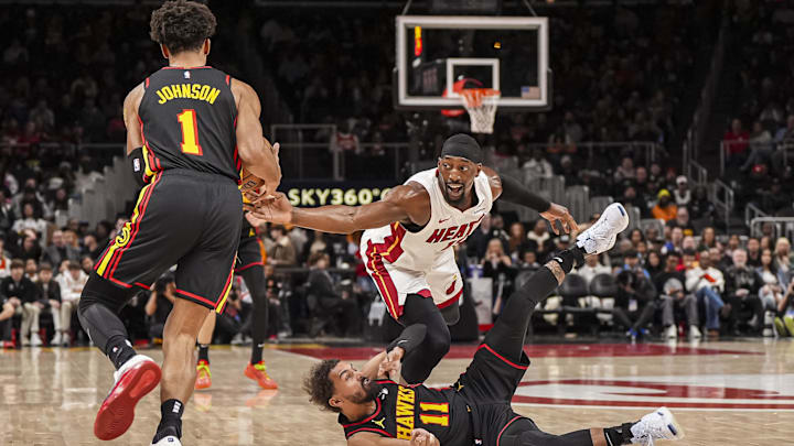 Dec 28, 2024; Atlanta, Georgia, USA; Atlanta Hawks guard Trae Young (11) passes the ball to forward Jalen Johnson (1) under Miami Heat center Bam Adebayo (13) during the first half at State Farm Arena. Mandatory Credit: Dale Zanine-Imagn Images