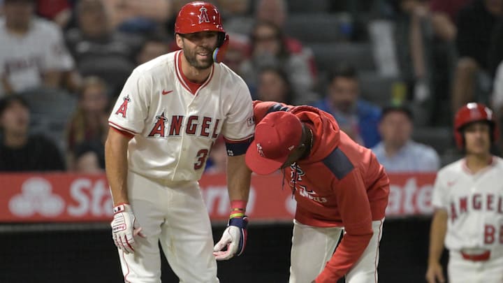 Jun 9, 2025; Anaheim, California, USA;  Los Angeles Angels manager Ron Washington (37) checks on center fielder Chris Taylor (33) after he was hit by a pitch in the left hand in the eighth inning against the Athletics at Angel Stadium. Taylor was diagnosed with a fracture in the hand. Mandatory Credit: Jayne Kamin-Oncea-Imagn Images