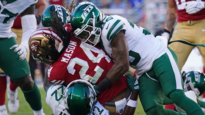 Sep 9, 2024; Santa Clara, California, USA; San Francisco 49ers running back Jordan Mason (24) is tackled by New York Jets safety Tony Adams (22) and New York Jets linebacker Quincy Williams (56) in the second quarter at Levi's Stadium. 