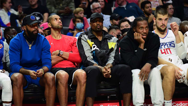 Oct 4, 2021; Los Angeles, California, USA; Los Angeles Clippers players Marcus Morris, Nicolas Batum, Serge Ibaka and Kawhi Leonard watch game action against the Denver Nuggets during the first half at Staples Center. Mandatory Credit: Gary A. Vasquez-Imagn Images