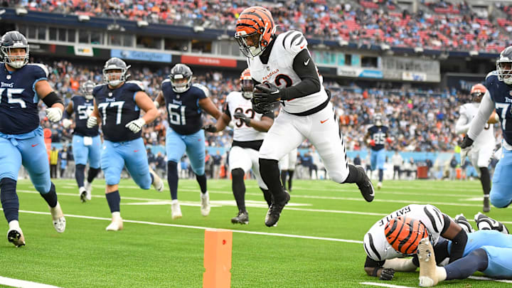 Dec 15, 2024; Nashville, Tennessee, USA;  Cincinnati Bengals safety Geno Stone (22) hurdles over safety Jordan Battle (27) for a pick six against the Tennessee Titans during the second half at Nissan Stadium. Mandatory Credit: Steve Roberts-Imagn Images