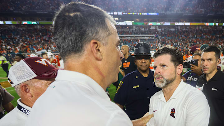Sep 27, 2024; Miami Gardens, Florida, USA; Virginia Tech Hokies head coach Brent Pry shakes hands with Miami Hurricanes head coach Mario Cristobal after the game at Hard Rock Stadium. Mandatory Credit: Sam Navarro-Imagn Images Sep 27, 2024; Miami Gardens, Florida, USA; Virginia Tech Hokies head coach Brent Pry shakes hands with Miami Hurricanes head coach Mario Cristobal after the game at Hard Rock Stadium. Mandatory Credit: Sam Navarro-Imagn Images
