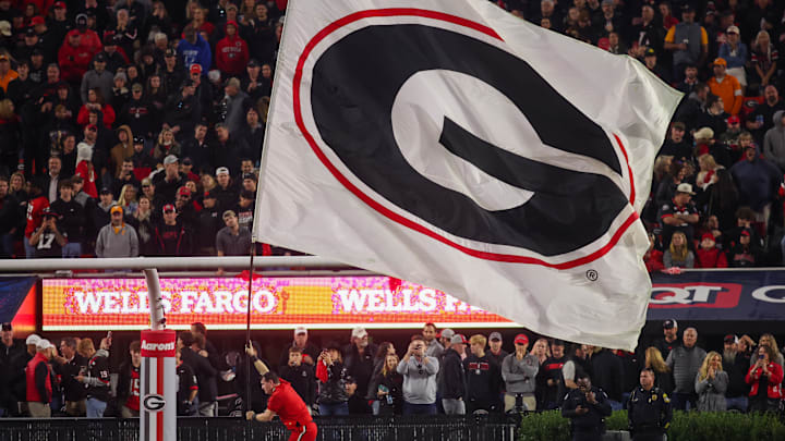 Nov 16, 2024; Athens, Georgia, USA; A Georgia Bulldogs cheerleader runs a flag against the Tennessee Volunteers in the fourth quarter at Sanford Stadium. Mandatory Credit: Brett Davis-Imagn Images
