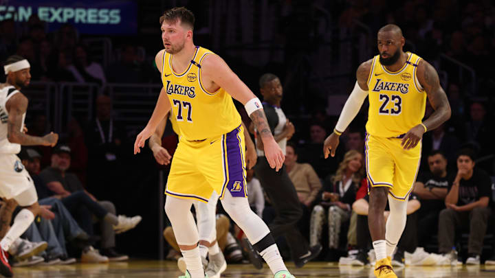 Feb 27, 2025; Los Angeles, California, USA: Los Angeles Lakers guard Luka Doncic (77) and forward LeBron James (23) defend during the second quarter against the Minnesota Timberwolves at Crypto.com Arena. Mandatory Credit: Jason Parkhurst-Imagn Images