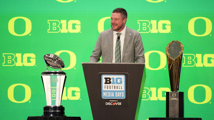The trophy to his right is the one Oregon won for winning the conference. To his left is the one that eluded him.