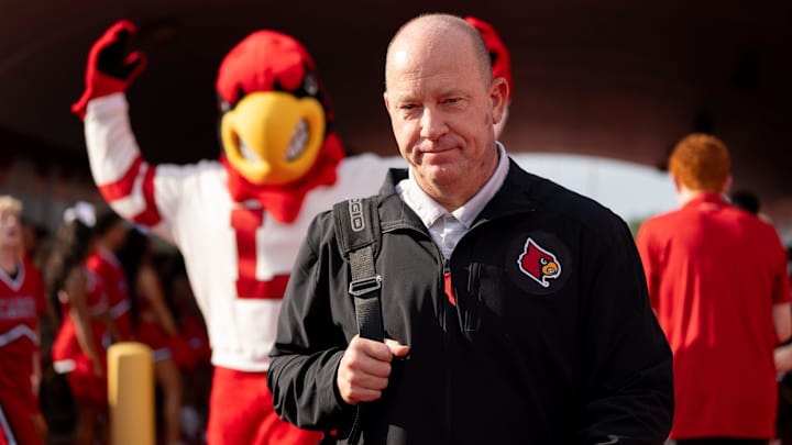 Louisville Cardinals head coach Jeff Brohm walks through the Card march 