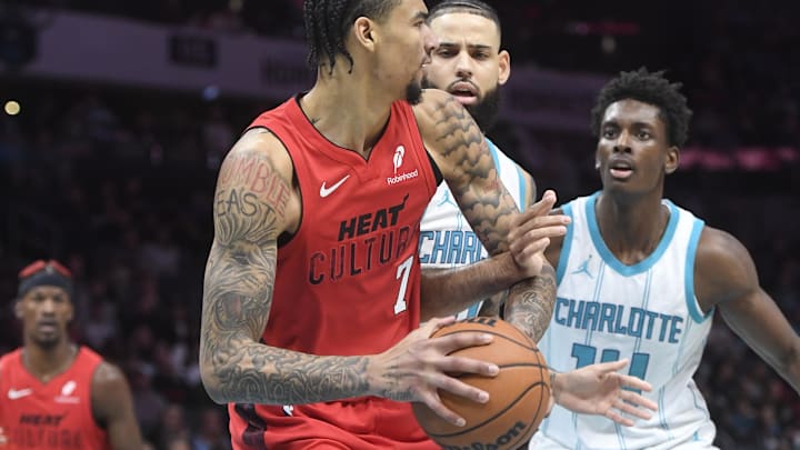 Nov 27, 2024; Charlotte, North Carolina, USA;  Miami Heat center Kel'el Ware (7) looks to pass as he is defended by Charlotte Hornets guard Cody Martin (11) and forward Moussa Diabate (14) during the first half at the Spectrum Center. Mandatory Credit: Sam Sharpe-Imagn Images