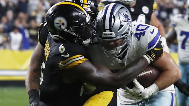 Oct 6, 2024; Pittsburgh, Pennsylvania, USA;  Dallas Cowboys running back Hunter Luepke (40) runs the ball as Pittsburgh Steelers linebacker Patrick Queen (6) defends during the fourth quarter at Acrisure Stadium.