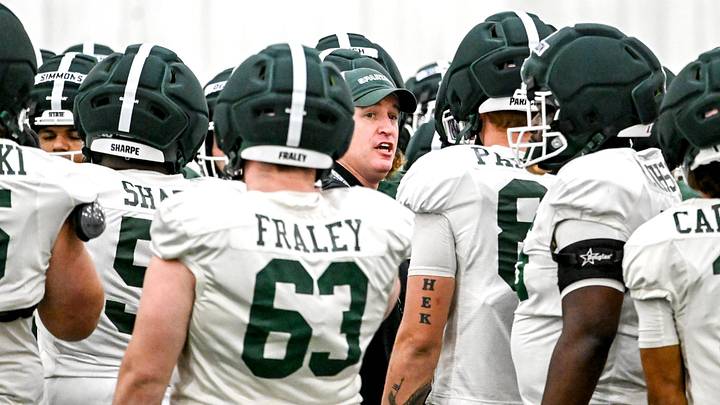 Michigan State's head coach Pat Fitzgerald, center, huddles up with the team during spring football practice on Tuesday, April 14, 2026, in East Lansing.