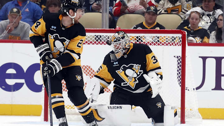 Oct 1, 2024; Pittsburgh, Pennsylvania, USA;  Pittsburgh Penguins goaltender Tristan Jarry (35) makes a save as defenseman Matt Grzelcyk (24) looks on against the Detroit Red Wings during the third period at PPG Paints Arena. Detroit won 2-1. Mandatory Credit: Charles LeClaire-Imagn Images