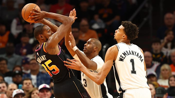 Dec 3, 2024; Phoenix, Arizona, USA; Phoenix Suns forward Kevin Durant (35) against San Antonio Spurs guard Chris Paul (3) and center Victor Wembanyama (1) in the first half of an NBA Cup game at Footprint Center. Mandatory Credit: Mark J. Rebilas-Imagn Images Dec 3, 2024; Phoenix, Arizona, USA; Phoenix Suns forward Kevin Durant (35) against San Antonio Spurs guard Chris Paul (3) and center Victor Wembanyama (1) in the first half of an NBA Cup game at Footprint Center. Mandatory Credit: Mark J. Rebilas-Imagn Images