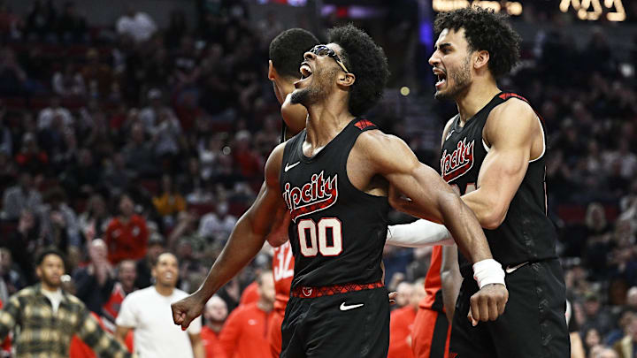 Apr 12, 2024; Portland, Oregon, USA; Portland Trail Blazers guard Scoot Henderson (00) reacts with teammate forward Justin Minaya (24) after dunking the basketball during the second half against the Houston Rockets at Moda Center. Mandatory Credit: Troy Wayrynen-Imagn Images