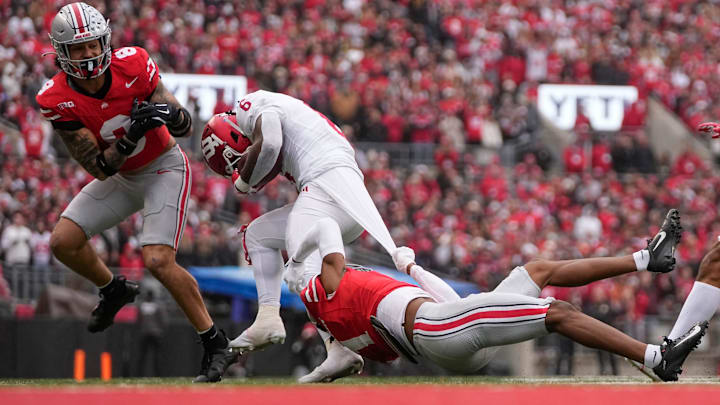 Ohio State Buckeyes cornerback Davison Igbinosun (1) and safety Lathan Ransom (8) tackle Indiana Hoosiers running back Justice Ellison (6) during the first half of the NCAA football game at Ohio Stadium in Columbus on Saturday, Nov. 23, 2024.