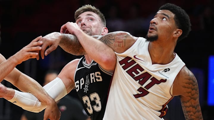 Oct 8, 2025; Miami, Florida, USA;  San Antonio Spurs center Micah Potter (33) battles for a rebound with Miami Heat center Kel'El Ware (7) during the second half at Kaseya Center. Mandatory Credit: Jim Rassol-Imagn Images