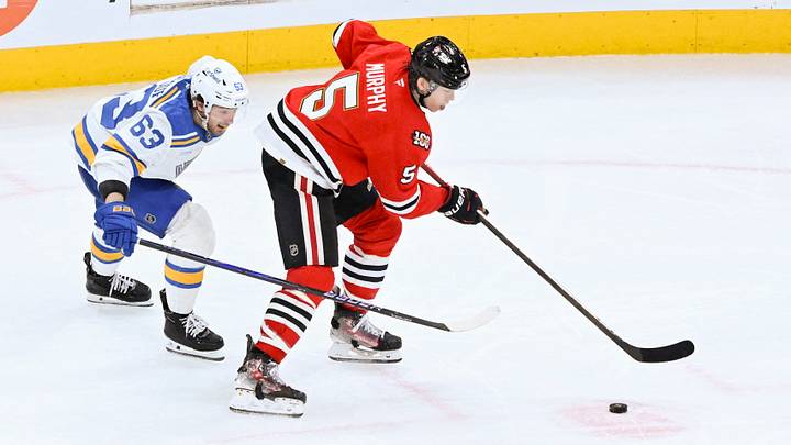 Jan 7, 2026; Chicago, Illinois, USA;  St. Louis Blues left wing Jake Neighbours (63) and Chicago Blackhawks defenseman Connor Murphy (5) chase the puck during the third period at the United Center. Mandatory Credit: Matt Marton-Imagn Images