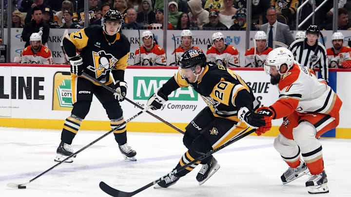 Oct 31, 2024; Pittsburgh, Pennsylvania, USA;  Pittsburgh Penguins center Lars Eller (20) handles the puck against pressure from Anaheim Ducks defenseman Radko Gudas (7) during the third period at PPG Paints Arena. Mandatory Credit: Charles LeClaire-Imagn Images