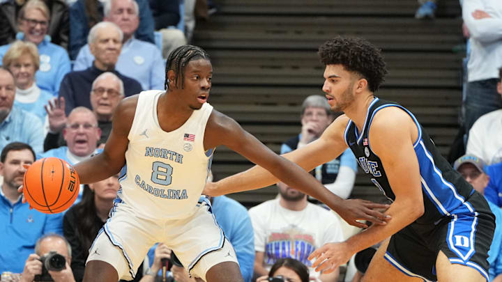 Feb 7, 2026; Chapel Hill, North Carolina, USA; North Carolina Tar Heels forward Caleb Wilson (8) with the ball as Duke Blue Devils forward Cameron Boozer (12) defends in the first  half at Dean E. Smith Center. Mandatory Credit: Bob Donnan-Imagn Images