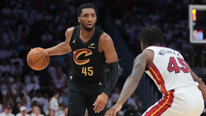 Apr 26, 2025; Miami, Florida, USA; Cleveland Cavaliers guard Donovan Mitchell (45) dribbles the basketball as Miami Heat guard Davion Mitchell (45) defends in the first quarter during game three for the first round of the 2025 NBA Playoffs at Kaseya Center. Mandatory Credit: Sam Navarro-Imagn Images