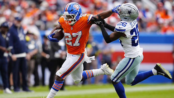 Denver Broncos running back J.K. Dobbins runs against Dallas Cowboys cornerback DaRon Bland. Denver Broncos running back J.K. Dobbins runs against Dallas Cowboys cornerback DaRon Bland.