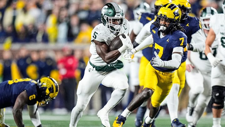 Michigan State running back Nate Carter (5) runs against Michigan defensive back Makari Paige (7) during the first half at Michigan Stadium in Ann Arbor on Saturday, Oct. 26, 2024.