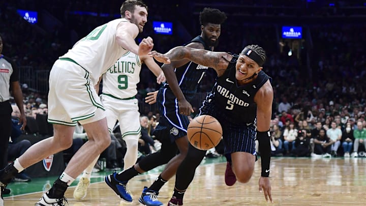 Boston Celtics center Luke Kornet (40) and Orlando Magic forward Paolo Banchero (5) battle for a loose ball during the first half at TD Garden.