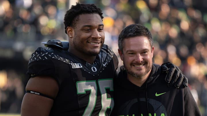 Oregon’s Isaiah World, left, takes a picture with coach Dan Lanning before the game against Southern California Nov. 22, 2025.