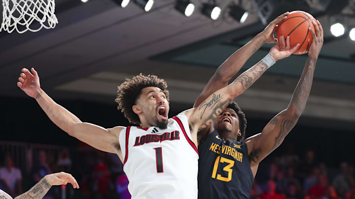 Nov 28, 2024; Paradise Island, Bahamas, BHS; West Virginia Mountaineers forward Amani Hansberry (13) tries to shoot as Louisville Cardinals guard J'Vonne Hadley (1) defends during the second half at Imperial Arena at the Atlantis resort. Mandatory Credit: Kevin Jairaj-Imagn Images Nov 28, 2024; Paradise Island, Bahamas, BHS; West Virginia Mountaineers forward Amani Hansberry (13) tries to shoot as Louisville Cardinals guard J'Vonne Hadley (1) defends during the second half at Imperial Arena at the Atlantis resort. Mandatory Credit: Kevin Jairaj-Imagn Images