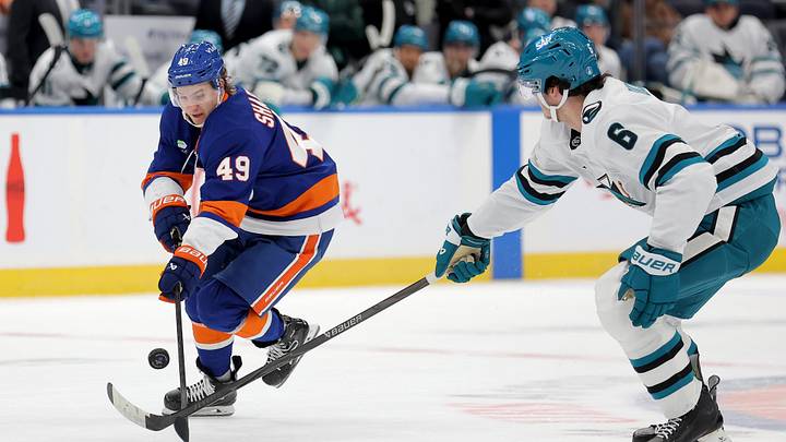 Oct 21, 2025; Elmont, New York, USA; New York Islanders right wing Maxim Shabanov (49) fights for the puck against San Jose Sharks defenseman Sam Dickinson (6) during the second period at UBS Arena. Mandatory Credit: Brad Penner-Imagn Images